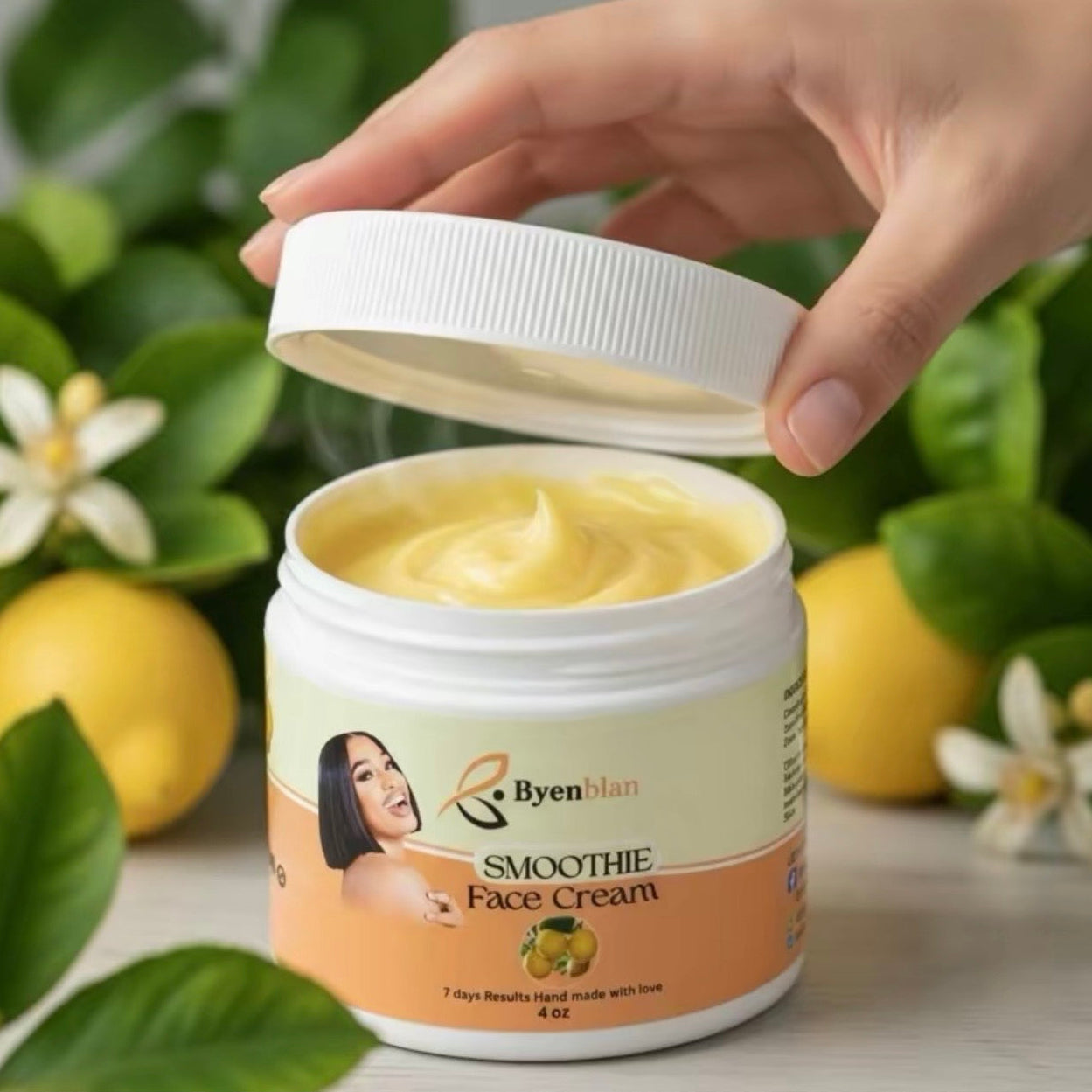 Byenlan Smoothie Face Cream jar with a hand lifting the lid against a natural background.